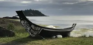 Black canoe with First Nations art